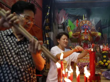 Beberapa orang menyalakan dupa saat festival Hungry Ghost di Kuala Lumpur, Malaysia, (3/8/2014). (REUTERS/Olivia Harris)