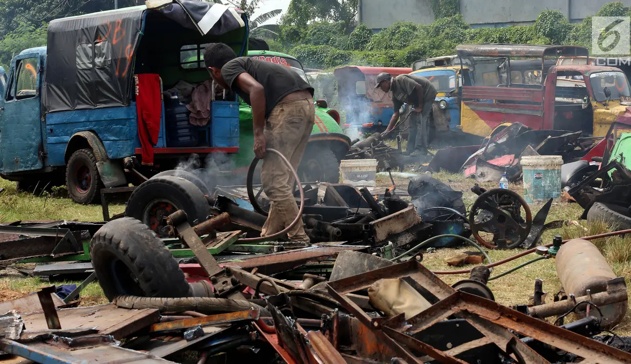 Pekerja memusnahkan bemo hasil razia di sejumlah wilayah di Jakarta, di pool Rawa Buaya, Cengkareng, Jakarta Barat, Selasa (1/8). Pemusnahan dilakukan, dikarenakan sejak 6 Juni 2017, Dishub DKI melarang bemo beroperasi. (Liputan6.com/Johan Tallo)
