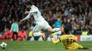 Gelandang Real Madrid, Marco Asensio berebut bola dengan pemain Juventus,  Douglas Costa pada leg kedua babak perempat final Liga Champions di Santiago Bernabeu, Rabu (11/4). Real Madrid melaju ke semifinal meski kalah 1-3. (CURTO DE LA TORRE/AFP)