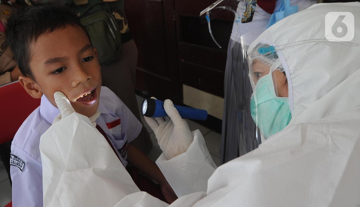 Tim medis puskesmas memeriksa murid Sekolah Dasar Negeri pada lingkungan Kecamatan Kebayoran Lama di GOR Kebayoran Lama, Jakarta, Rabu (26/08/2020). Kegiatan ini bagian dari bulan imunisasi anak sekolah dan juga pemeriksaan kesehatan menyeluruh kepada murid SDN di DKI. (merdeka.com/Arie Basuki)