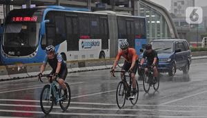 Warga bersepeda saat hujan turun di kawasan Bundaran HI, Jakarta, Minggu (24/1/2021). Kepala BMKG Dwikorita mengatakan, puncak musim hujan akan terjadi pada Januari dan Februari 2021, sehingga perlu diwaspadai terjadinya cuaca ekstrem. (Liputan6.com/Herman Zakharia)
