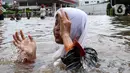 Seorang anak bermain banjir yang merendam kawasan Green Garden, Jakarta Barat, Selasa (25/2/2020). Hujan yang mengguyur kawasan Jakarta membuat kawasan tersebut tergenang banjir setinggi 60-80 cm. (Liputan6.com/Johan Tallo)