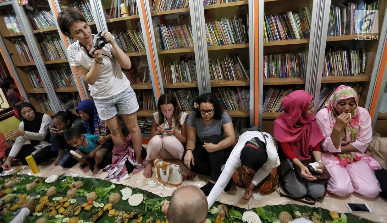Sejumlah anak yatim, kaum dhuafa serta lima warga negara asing (WNA) menikmati nasi liwet sambil lesehan di Rumah Amalia, Ciledug, Kota Tangerang, Sabtu (3/3). Mereka berbaur menikmati makanan yang disajikan dengan daun pisang. (Liputan6.com/Fery Pradolo)