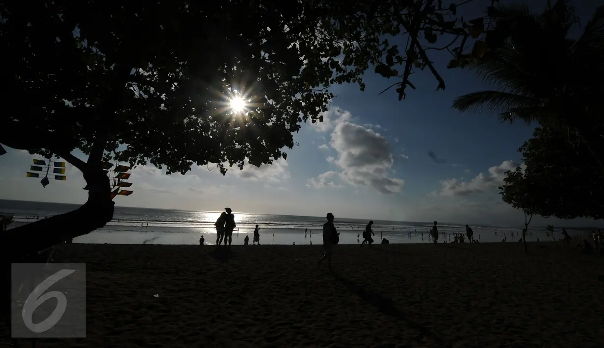 Sejumlah wisatawan menikmati terik matahari di kawasan Pantai Kuta, Bali, 31 Agustus 2015. Pantai Kuta masih menjadi lokasi wisata utama bagi wisatawan yang berkunjung ke Bali. (Liputan6.com/Helmi Fithriansyah)