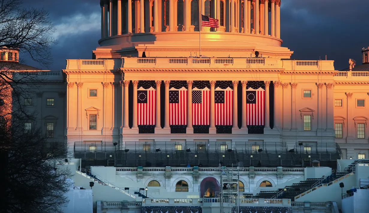 Gedung Capitol di Washington DC telah dihiasi dengan bendera Amerika Serikat, Kamis (19/1). Gedung Capitol terlihat sedang dipersiapkan sebagai tempat pelantikan presiden terpilih Donald Trump di Washington. (Mario Tama/Getty Images/AFP)
