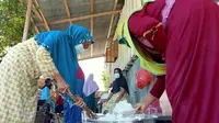 Aktivitas Ibu-ibu dengan gerakan 'Sigi Mosi Jagai' di Desa Langaleso, Sigi saat memasak untuk kebutuhan makanan warga yang menjalani isolasi mandiri, Senin (16/8/2021). (Foto: Heri Susanto/ Liputan6.com).