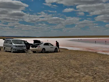 Wisatawan beristirahat di dekat Danau Kobeituz di Kawasan Akmola, Kazakhstan utara (20/6/2020). Danau Kobeituz terkenal dengan warna merah mudanya dan populer di kalangan wisatawan lokal. (Xinhua/Kalizhan Ospanov)