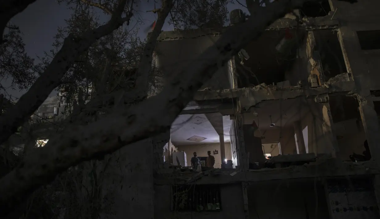 Warga Palestina bermalam di samping rumah mereka yang hancur baru-baru ini terkena serangan udara Israel di kota Beit Hanoun, Jalur Gaza utara, Rabu (26/5/2021). Warga Palestina mulai kembali ke rumah mereka yang hancur setelah gencatan senjata diberlakukan dalam perang Gaza. (AP Photo/Khalil Hamra)