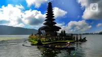 Warga yang naik perahu melintas dekat Pura Ulun Danu Beratan di Kecamatan Baturiti, Tabanan, Bali, Senin (24/04/2023). Sejumlah objek wisata di Pulau Dewata diserbu wisatawan domestik asal kota-kota besar di Pulau Jawa saat momen libur Idul Fitri 1444 Hijriah. (merdeka.com/Arie Basuki)