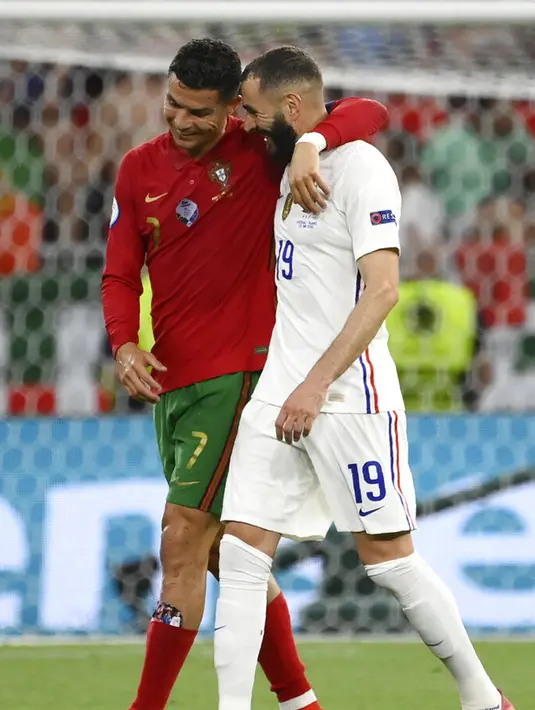 Pemain Portugal Cristiano Ronaldo (kiri) dan pemain Prancis Karim Benzema (kanan) meninggalkan lapangan bersama saat turun minum pada pertandingan Grup F Euro 2020 di Puskas Arena, Budapest, Hungaria, Rabu (23/6/2021). Laga berakhir imbang 2-2. (Franck Fife, Pool photo via AP)