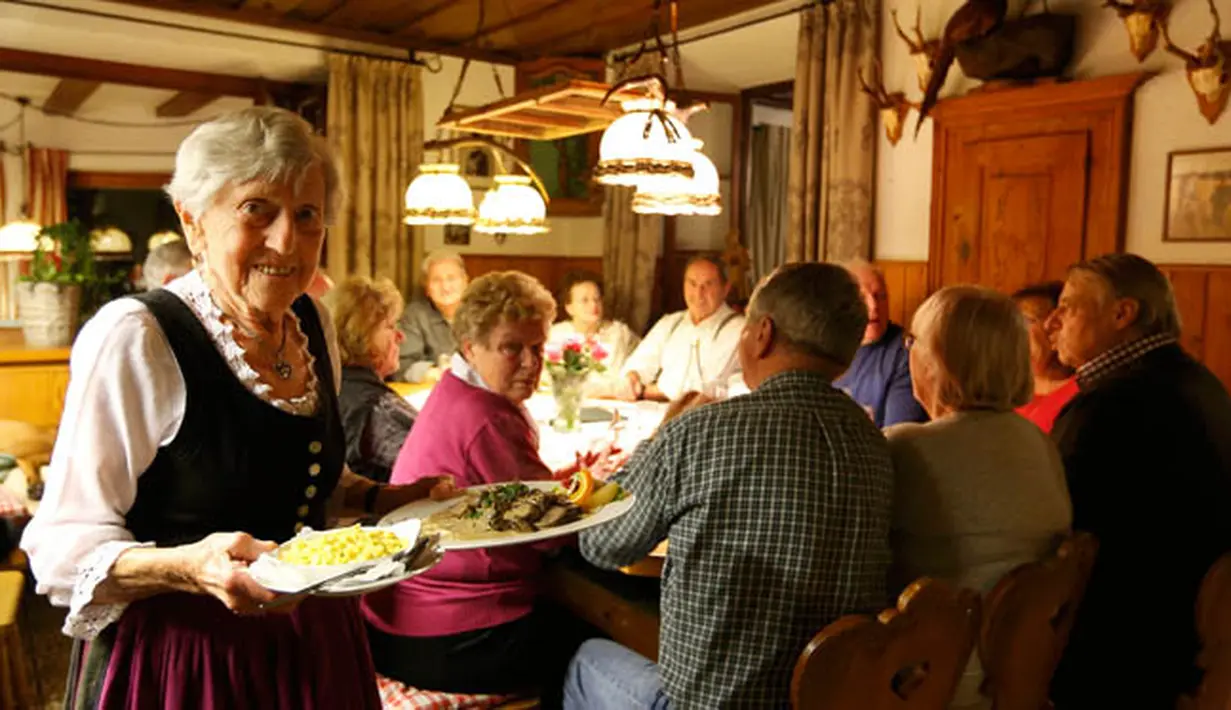 Kathi Kink mengantar pesanan makanan pengunjung di restoran 'Zum Goldenen Tal' di Weyarn, Jerman. Foto diambil pada 1 Februari 2015. (REUTERS/Michaela Rehle)