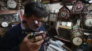 Hussein Mahmud (45) asal Irak saat memperbaiki jam kuno di gudangnya di daerah Maidan Baghdad (20/2). Mahmud memulai pekerjaan ini 30 tahun yang lalu dan mengatakan bahwa dia diajar oleh ayahnya. (AFP Photo/Ahmad Al-Rubaye)