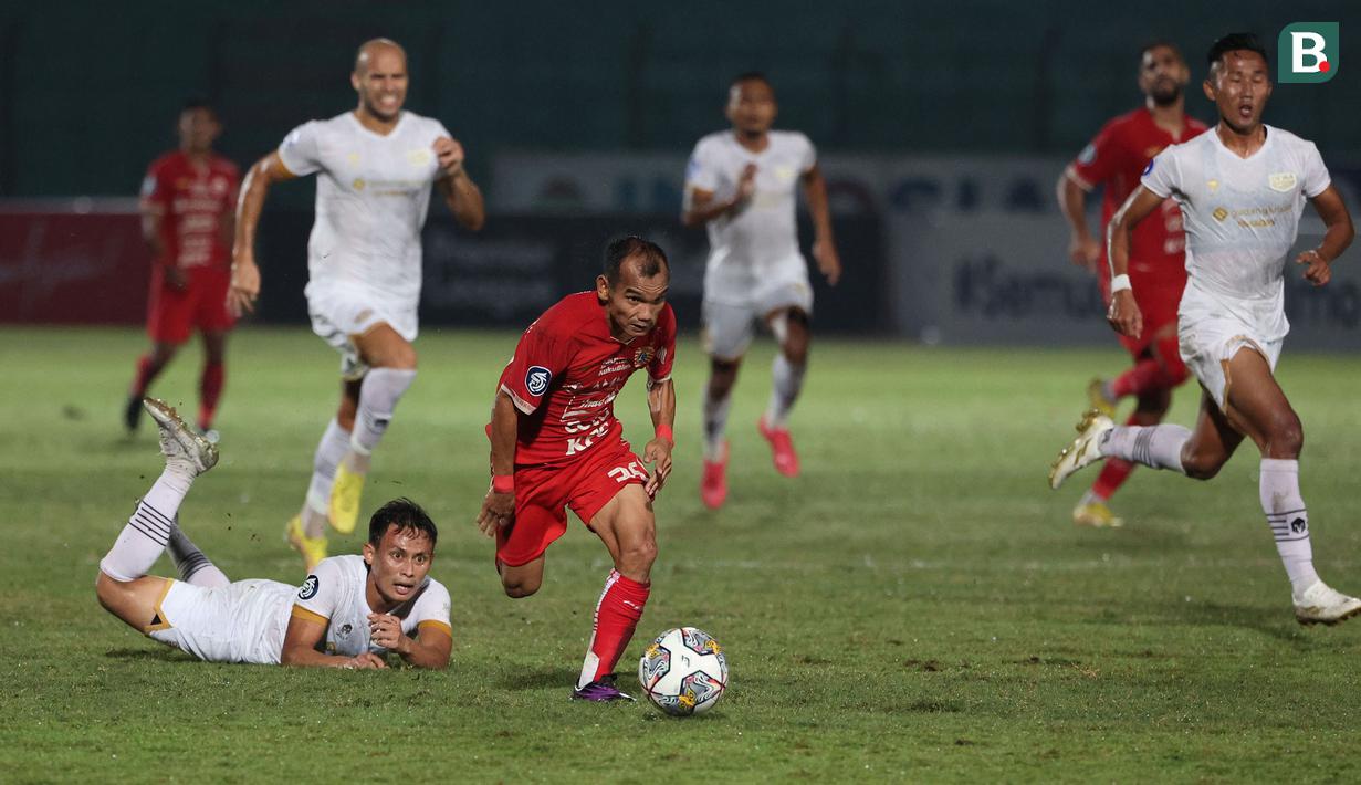 Pemain Persija Jakarta, Riko Simanjuntak (tengah) berhasil melewati pemain Dewa United, Dias Angga Putra dalam laga pekan ke-16 BRI Liga 1 2022/2023 di Stadion Sultan Agung, Bantul, Yogyakarta, Selasa (20/12/2022) malam WIB. (Bola.com/Ikhwan Yanuar)