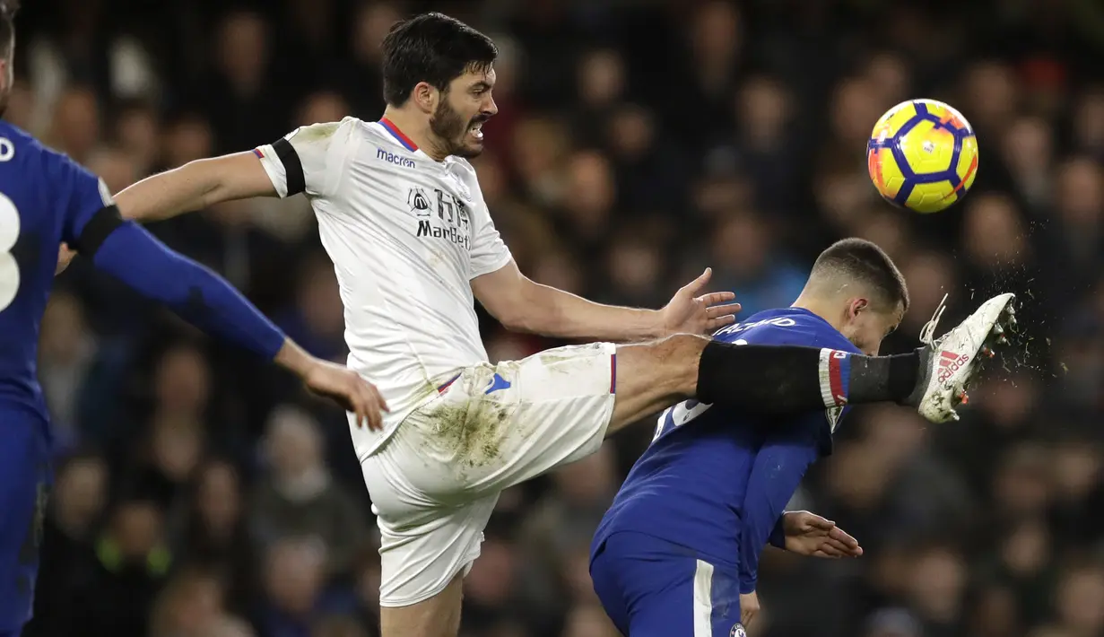 Aksi pemain Crystal Palace, James Tomkins (tengah) menghalau bola dari kejaran pemain Chelsea, Eden Hazard (kanan) pada lanjutan Premier League di Stamford Bridge stadium, London, (10/3/2018). Chelsea menang 2-1.(AP/Matt Dunham)