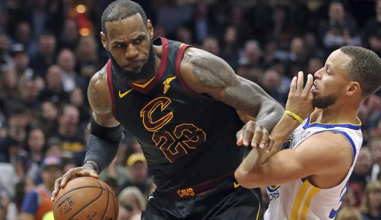 Pemain Cleveland, LeBron James (kiri) mencoba melewati adangan pemain Warriors, Stephen Curry pada gim ketiga final NBA basketball di Quicken Loans Arena, (6/6/2018). Warriors kalahkan Cavaliers 110-102. (Joshua Gunter/The Plain Dealer via AP)