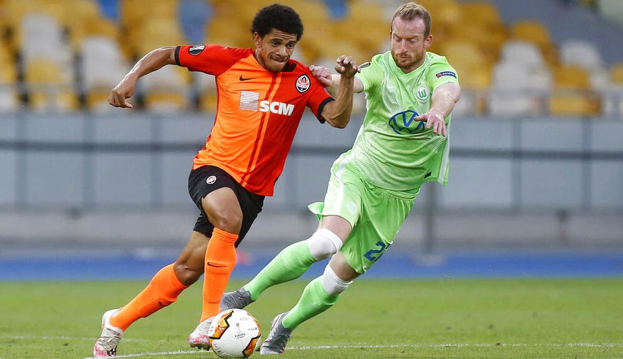 Pemain FC Shakhtar Donetsk, Taison, berebut bola dengan pemain VfL Wolfsburg, Maximilian Arnold, pada laga Liga Europa di Stadion NSK Olimpiyskiy, Kiev, Rabu (5/8/2020). Shakhtar Donetsk menang 3-0 atas Wolfsburg. (AP/Efrem Lukatsky)
