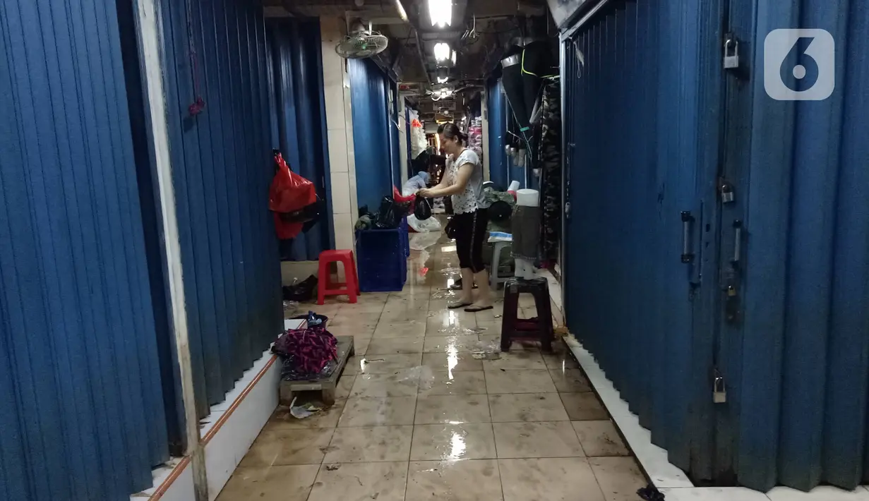 Pedagang merapikan tokonya usai banjir merendam Pasar Cipulir, Jakarta, Jumat (3/1/2020). Meski banjir telah surut, akitivitas jual beli di Pasar Cipulir masih belum kembali normal. (Liputan6.com/Angga Yuniar)