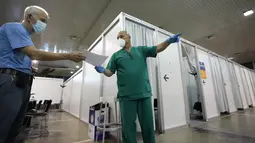Pekerja medis memberikan arahan saat orang-orang tiba untuk divaksin COVID-19 di pusat vaksinasi darurat Belgrade Fair di Belgrade, Selasa (17/8/2021). Serbia mulai memberikan dosis ketiga atau booster untuk mereka yang sebelumnya telah divaksinasi minimal 6 bulan lalu. (AP Photo/Darko Vojinovic)