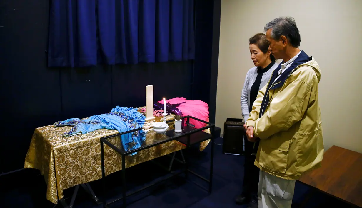 Hirokazu Hosaka (kanan) dan istrinya, Minako Hosaka mengamati peti mati ibunya di 'Corpse Hotel' di Kawasaki, Jepang, 20 April 2016. Tempat itu adalah kamar mayat yang didesain untuk menyimpan jenazah yang menunggu jadwal kremasi. (REUTERS/Thomas Peter)