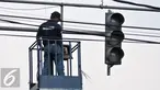 Petugas Dinas Perhubungan DKI Jakarta mengecek lampu lalu lintas di kawasan Manggarai, Jakarta, Selasa (19/7). Untuk mencegah kemacetan akibat trafic light, Dishub ganti lampu lalin yang bermasalah. (Liputan6.com/Yoppy Renato)