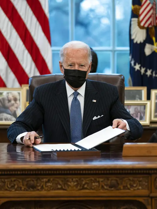 Presiden Amerika Serikat Joe Biden setelah menandatangani Perintah Eksekutif yang membatalkan larangan bagi transgender untuk masuk militer AS pada era Donald Trump di Kantor Oval Gedung Putih, Washington, Senin (25/1/2021). (AP Photo/Evan Vucci)