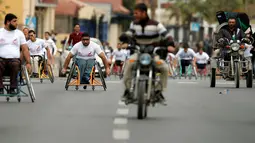 Sejumlah warga difable Palestina mengayuh roda saat bersaing dalam perlombaan kursi roda yang diselenggarakan oleh Masyarakat Amal Assalama di Kota Gaza, (29/11). (REUTERS/Suhaib Salem)