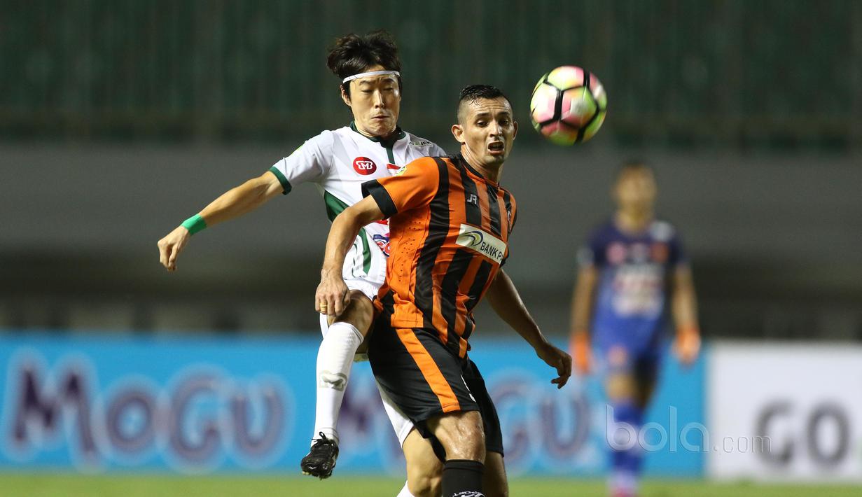 Pemain PS TNI, Hong Soon-hak berusaha melewati adangan pemain Perseru Serui, Silvio Escobar pada laga Liga 1 2017 di Stadion Pakansari, Bogor, Minggu (18/6/2017). PS TNI menang 1-0. (Bola.com/Nicklas Hanoatubun)