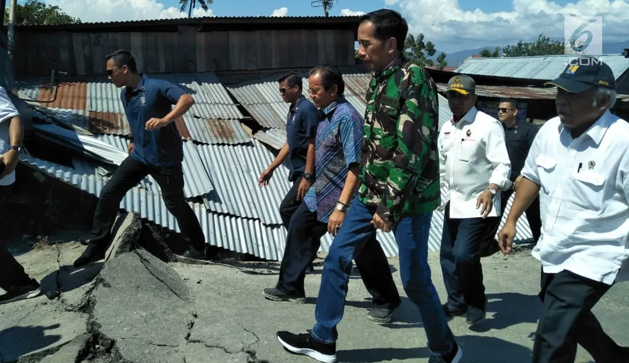 Presiden Joko Widodo (Jokowi) meninjau sejumlah titik yang terdampak bencana gempa dan tsunami di Kota Palu, Sulawesi Tengah, Minggu (30/9). Jokowi yang didampingi sejumlah jajarannya tampak mengenakan jaket loreng khas TNI. (Liputan6.com/Septian Deny)