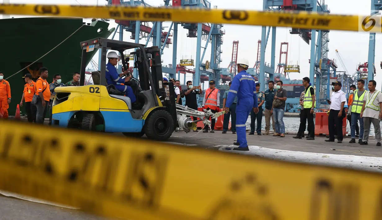 Petugas memindahkan salah satu bagian dari roda pesawat Lion Air PK-LQP JT 610 di Pelabuhan JICT 2, Jakarta, Senin (5/11). Bagian tersebut dipindah untuk dilakukan identifikasi dan pengecekan lebih lanjut oleh KNKT. (Liputan6.com/Helmi Fithriansyah)