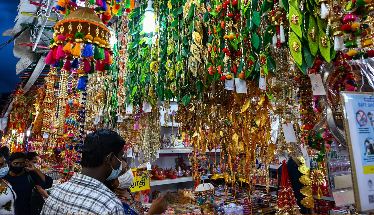 Orang-orang berjalan melintasi sepanjang toko yang menjual ornamen dan dekorasi menjelang Diwali, festival cahaya bagi umat Hindu, di distrik Little India di Singapura pada 23 Oktober 2020. (Photo by Roslan RAHMAN / AFP)
