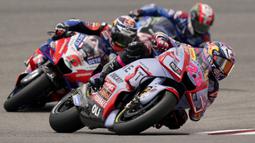 Enea Bastianini (depan) yang memulai start dari posisi kelima baru berhasil memimpin balapan hingga akhirnya menjadi juara usai melewati Jack Miller yang terus memimpin sejak awal. Ia melakukannya di lap ke-16. (AP/Eric Gay)