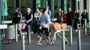 Orang-orang mengantre di luar supermarket ketika Selandia Baru akan beralih ke pembatasan level 3 di Hobsonville, Auckland, Rabu (12/8/2020). Selandia Baru akan memberlakukan lockdown di Auckland setelah ditemukan 4 kasus baru COVID-19 di kota itu. (Dean Purcell/New Zealand Herald via AP)