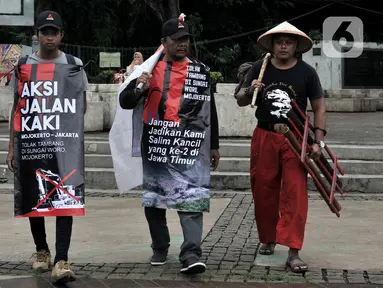Tiga warga Mojokerto, Ahmad Yani (45), Sugiantoro (31), dan Heru Prasetiyo (24) bersama aktivis saat tiba di seberang Istana Negara, Jakarta, Kamis (6/2/2020). Mereka berjalan kaki dari Mojokerto meminta pemerintah menghentikan aktivitas penambangan di Sungai Woro. (merdeka.com/Iqbal S Nugroho)