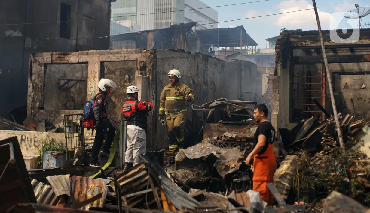 Petugas saat berusaha memadamkan sisa api yang membakar toko dan pemukiman warga di kawasan Manggarai, Jakarta, Selasa (7/7/2020). Tidak ada korban jiwa dalam peristiwa itu, namun akibat kebakaran sebanyak 40 bangunan yang didominasi toko mebel ludes terbakar. (Liputan6.com/Immanuel Antonius)