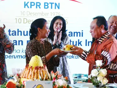 Menteri BUMN Rini M Soemarno memberi tumpeng kepada Dirut Bank BTN, Maryono saat acara HUT KPR BTN di Menara BTN, di Jakarta Selasa (14/12). Perayaan ditandai dengan pemotongan tumpeng oleh Rini. (Liputan6.com/Angga Yuniar)