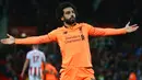 Gelandang Liverpool, Mohamed Salah berselebrasi setelah berhasil mencetak gol ke gawang Stoke City pada pekan ke-14 Premier League di Bet365 Stadium, Kamis (30/11). Dua gol Salah sukses mencukur Stoke City 3-0. (Geoff CADDICK/AFP)