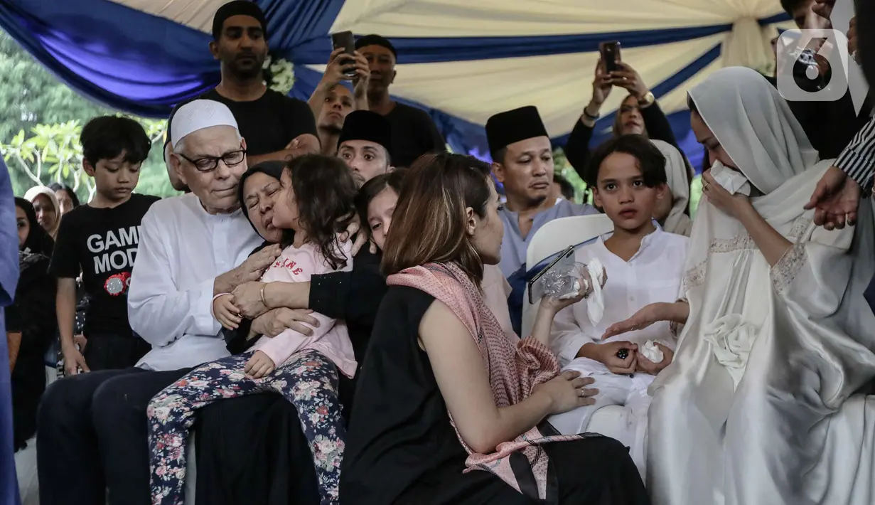Bunga Citra Lestari atau BCL (kanan) bersama anaknya Noah Sinclair saat pemakaman jenazah Ashraf Sinclair di San Diego Hills, Karawang, Jawa Barat, Selasa (18/2/2020). Tangis keluarga dan kerabat pecah saat pemakaman Ashraf Sinclair. (Liputan6.com/Faizal Fanani)
