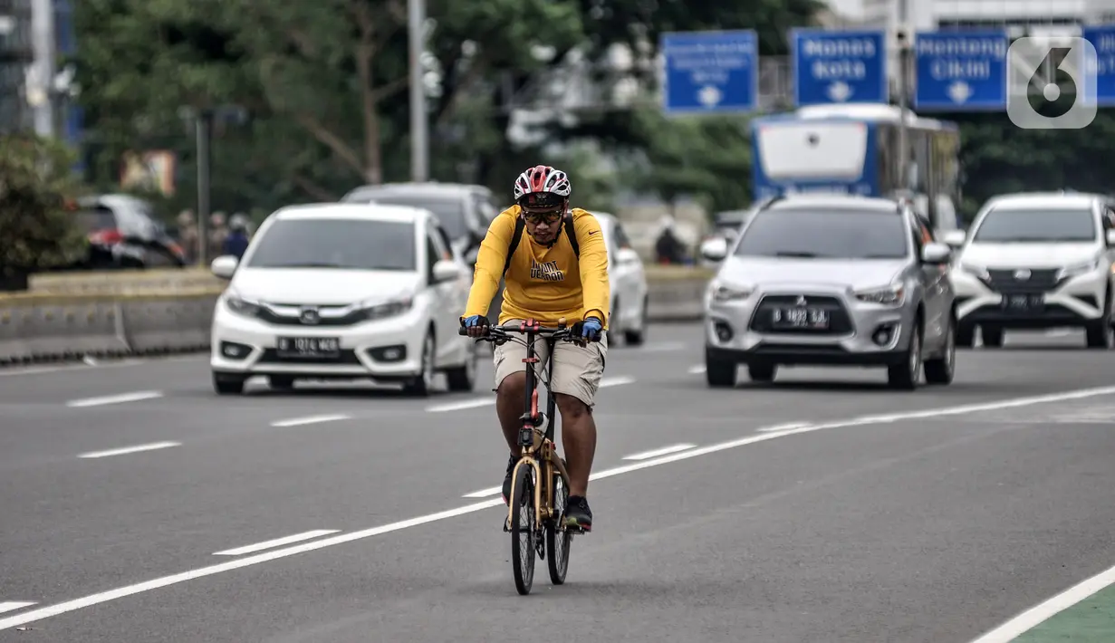 Pesepeda melintasi Jalan Jenderal Sudirman, Jakarta, Senin (18/1/2021). Dinas Perhubungan Provinsi DKI Jakarta mencatat volume lalu lintas pesepeda mengalami peningkatan 4,1 persen selama sepekan pengetatan Pembatasan Sosial Berskala Besar (PSBB). (merdeka.com/Iqbal S. Nugroho)