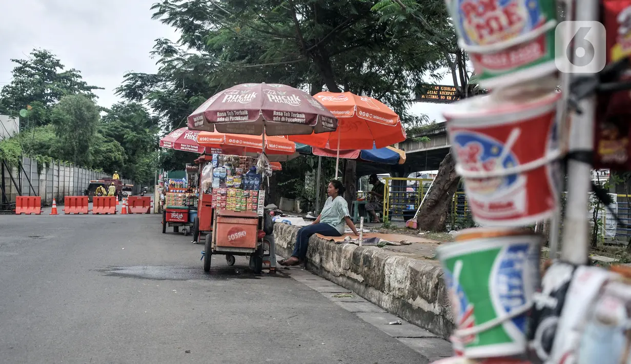 Pedagang berjualan di Jalan Inspeksi Kali Ancol jelang gelaran balap liar legal, Pademangan, Jakarta Utara, Rabu (12/1/2022). Balap liar legal yang dinamai Street Race rencananya akan digelar perdana pada akhir pekan mendatang. (merdeka.com/Iqbal S. Nugroho)