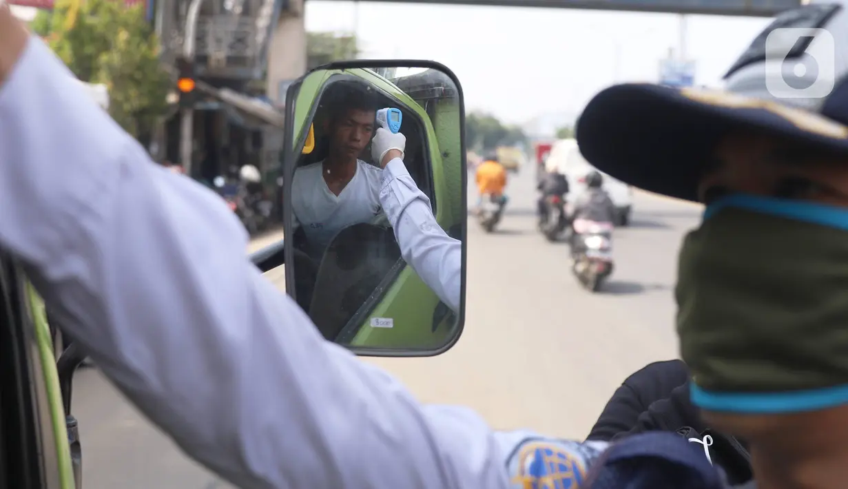 Petugas memeriksa suhu tubuh pengemudi truk saat pelaksanaan Pembatasan Sosial Berskala Besar (PSBB) di kawasan Gading Serpong, Tangerang Selatan, Sabtu (18/4/2020). Pengukuran suhu tubuh tersebut merupakan cek point dari PSBB yang baru saja diberlakukan di Tangerang Raya (Liputan6.com/Angga Yuniar)