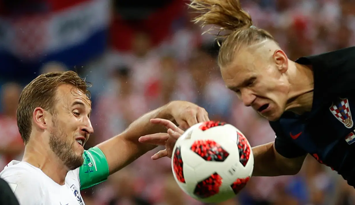 Pemain timnas Kroasia, Domagoj Vida berebut bola dengan pemain Inggris, Harry Kane pada babak semifinal Piala Dunia 2018 di Stadion Luzhniki, Rabu (11/7). Kroasia memastikan diri maju ke final seusai mengandaskan Inggris 2-1. (AP/Francisco Seco)