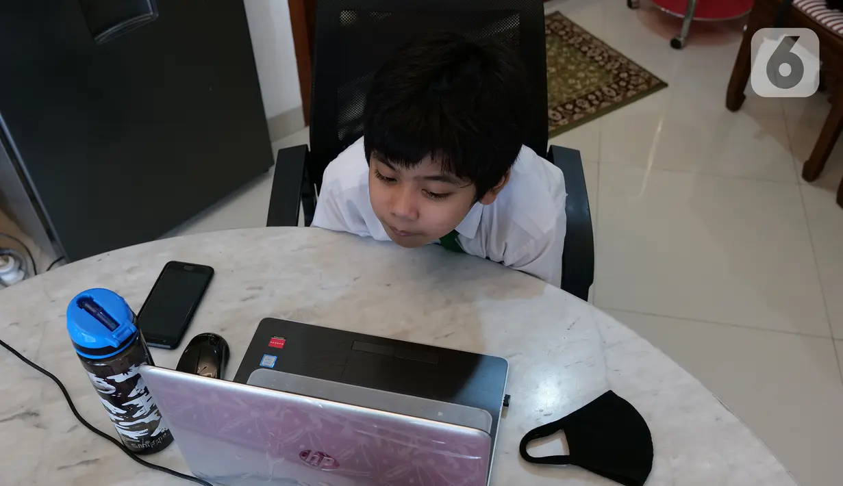 Siswa SD Islam Al Azhar 4 Muhammad Risyad (10) saat mengikuti kegiatan belajar mengajar secara daring dari kediamannya di Bintaro, Jakarta, Senin (13/7/2020). Memasuki tahun ajaran baru, kegiatan belajar mengajar diawali dengan perkenalan para siswa. (Liputan6.com/Herman Zakharia)