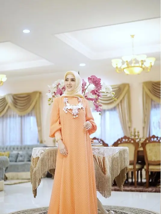 Gaun warna oranye yang sederhana menjadi terlihat fashionable saat dikenakan Syahrini. Tak lupa juga dihiasi dengan kalung cantik. (Liputan6.com/Instagram/@princessyahrini)