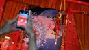 Pengunjung mengambil gambar dari atraksi Aero Silk-oriental Acrobatic di salah satu pusat perbelanjaan di Jakarta, Jumat (29/1). Dalam rangka Imlek 2567, sejumlah pusat perbelanjaan menggelar berbagai atraksi budaya Tionghoa. (Liputan6.com/Gempur M Surya)