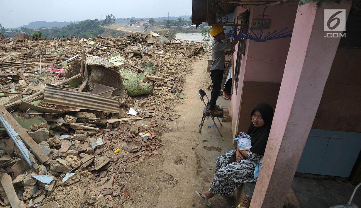 Warga duduk di rumah sebuah yang terkena proyek pembangunan Bendungan Ciawi di Desa Gadog, Bogor, Jawa Barat, Kamis (22/08/2019). Bendungan Ciawi semula ditargetkan selesai pada akhir 2019, namun progres pembebasan lahan berjalan lambat. (Merdeka.com/Arie Basuki)