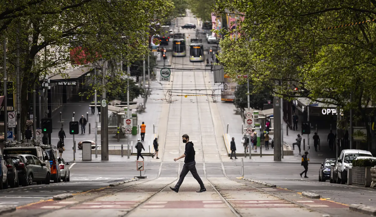 Orang-orang melintasi Bourke Street di Melbourne, Australia, Kamis (30/9/2021). Infeksi Covid-19 di Melbourne melonjak ke level rekor dengan sebanyak 1.438 infeksi baru ditemukan di kota terbesar kedua Australia itu. (Daniel Pockett/AAP Image via AP)