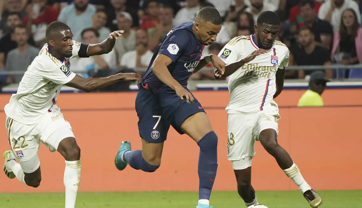 Pemain Paris Saint-Germain (PSG), Kylian Mbappe, berusaha melewati pemain Lyon, Clinton Mata (kiri) dan Ainsley Maitland-Niles pada laga pekan keempat Ligue 1 2023/2024 di Groupama Stadium, Senin (04/09/2023). PSG menang dengan skor 4-1. (AP Photo/Laurent Cipriani)
