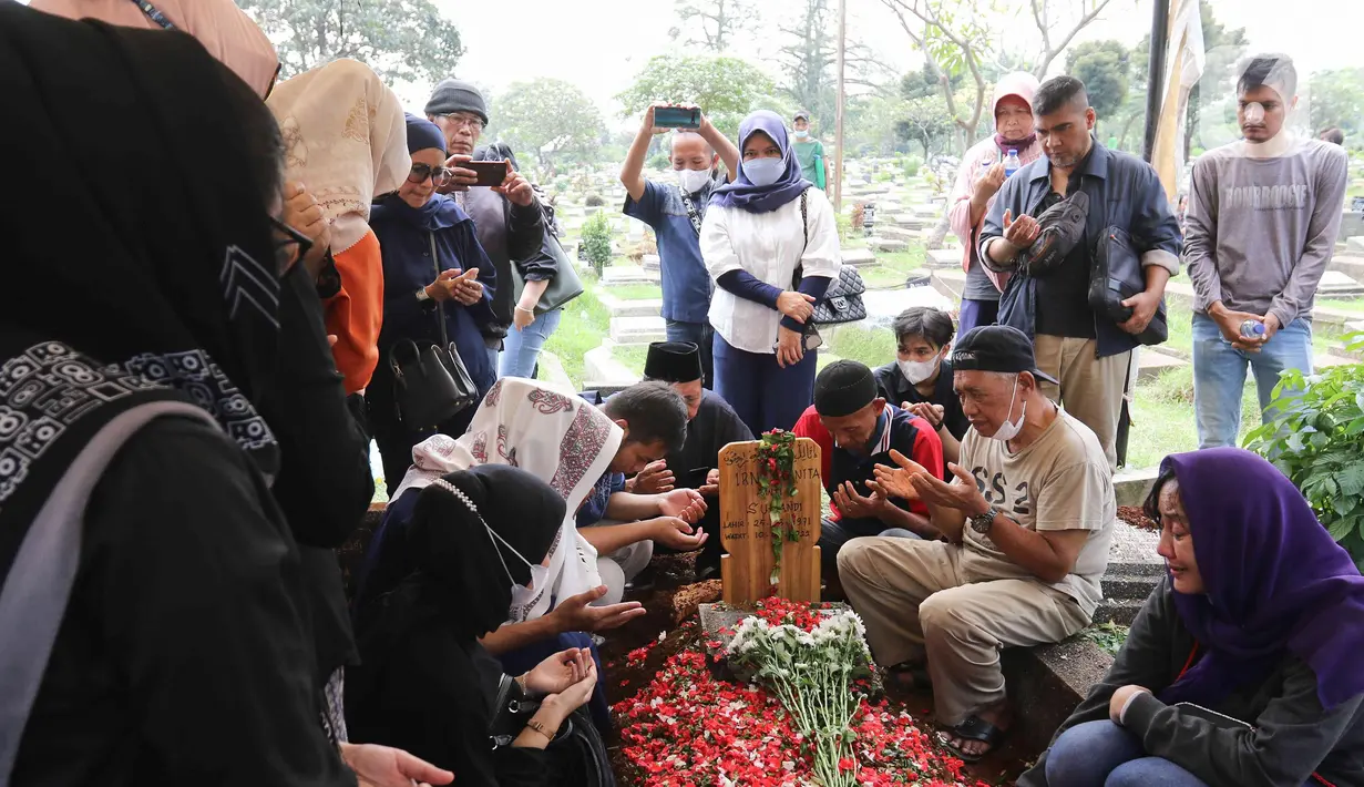 Keluarga dan kerabat berdoa di dekat makam pelawak Irni Yusnita  alias Rini S Bon Bon di TPU Kawi Kawi, Johar Baru, Jakarta, Senin (11/7/2022). Pelawak Rini S Bon Bon  meninggal dunia pada hari Minggu sore (10/7/2022), sebelum berpulang rini sempat mengidap  sakit diabetes. (Liputan6.com/Herman Zakharia)