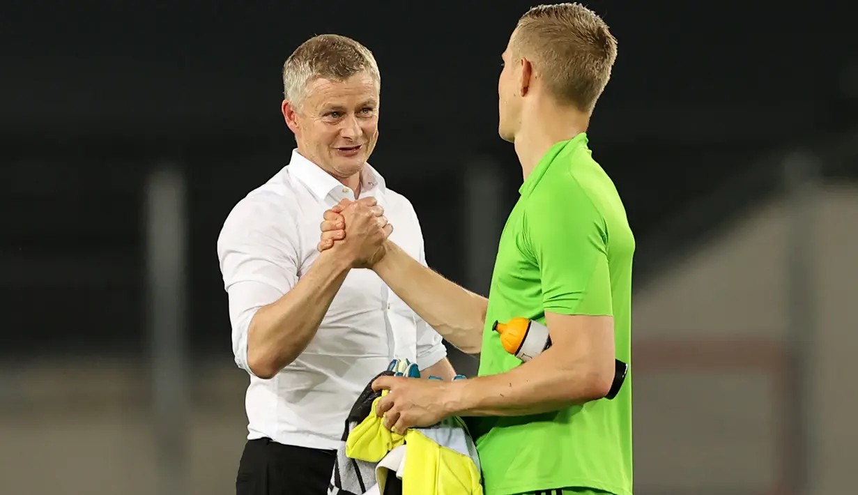 Pelatih Manchester United, Ole Gunnar Solskjaer bersalaman dengan kiper Copenhagen, Karl-Johan Johnsson usai pertandingan perempat final Liga Europa di RheinEnergieStadion, di Cologne, Jerman (10/8/2020). MU lolos ke babak semifinal Liga Europa usai menang 1-0. (AFP/Pool/Wolfgang Rattay)