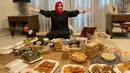 Berpose dengan banyak makanan untuk berbuka puasa, Rieta Amilia tampak kembali tampil kasual dengan dress gamis hitam polos, yang dipadunya dengan jilbab segiempat berwarna magenta. Foto: Instagram.
